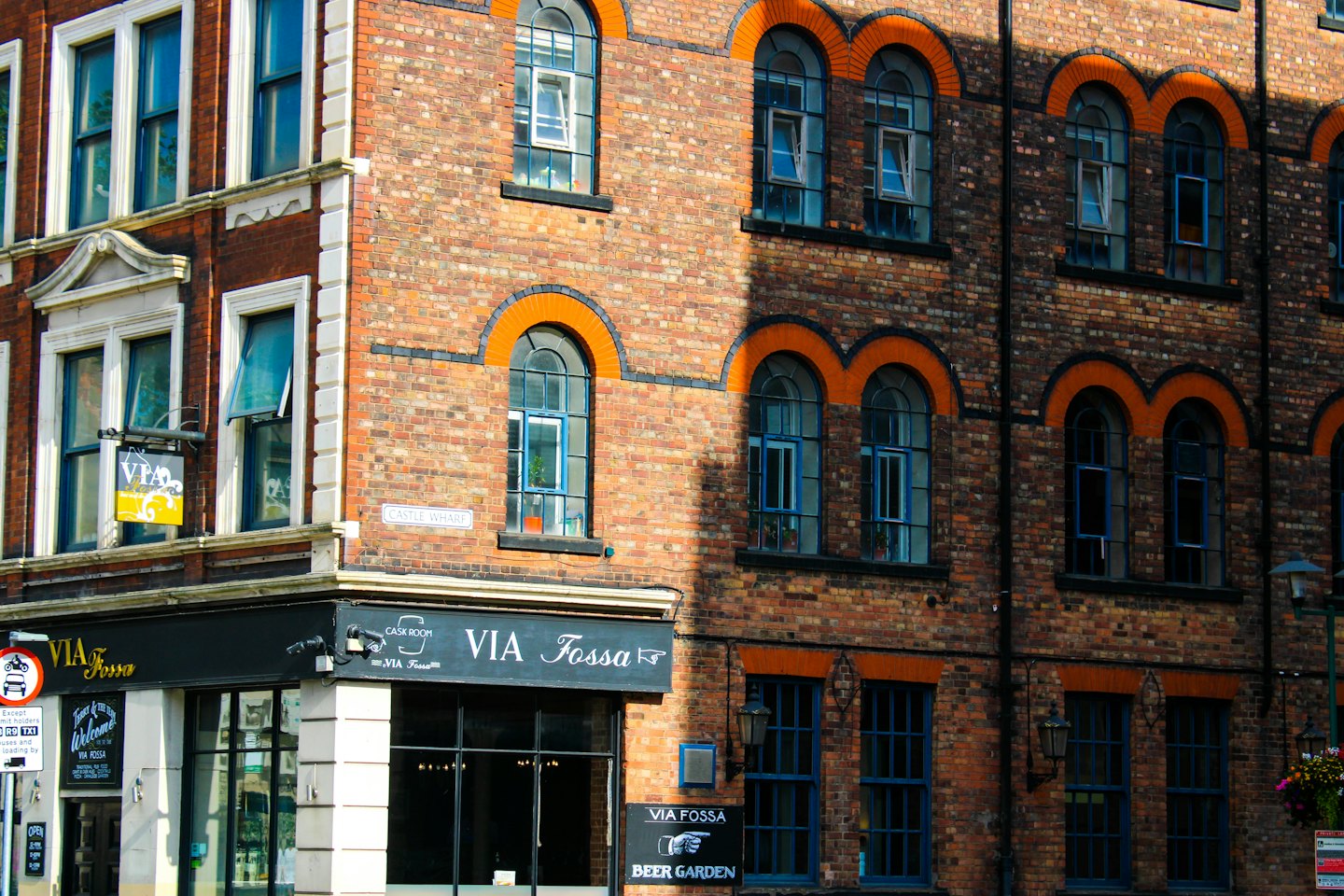 Multi-story brick building with arched windows and ground floor storefronts.